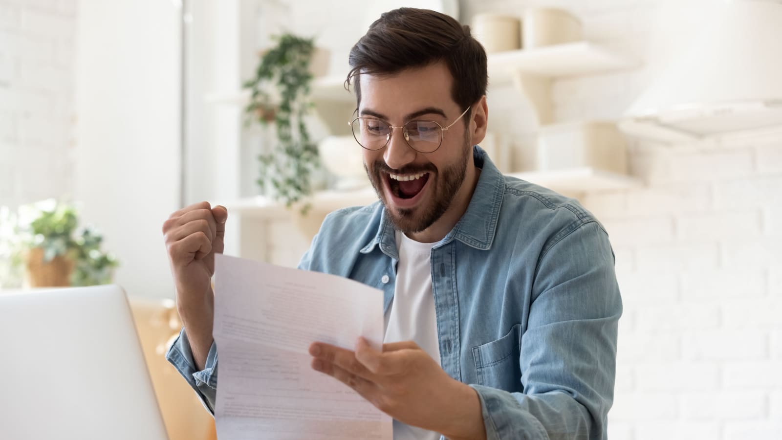 A man celebrates as he looks at his tax forms to represent getting a tax refund.