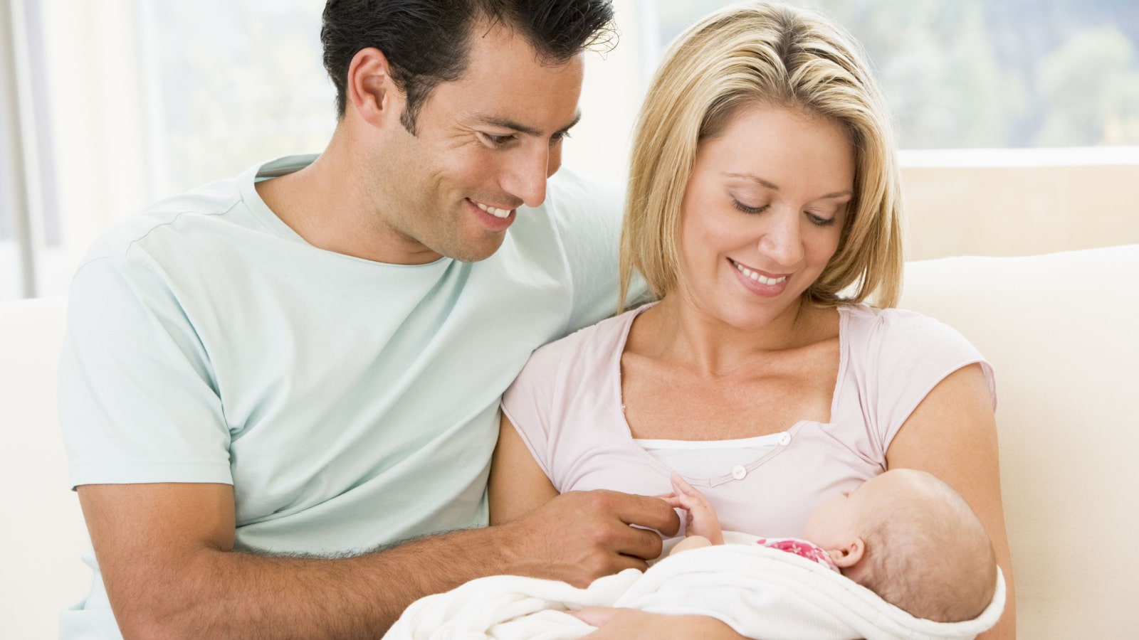 A happy couple holding their newborn after deciding to have a baby.