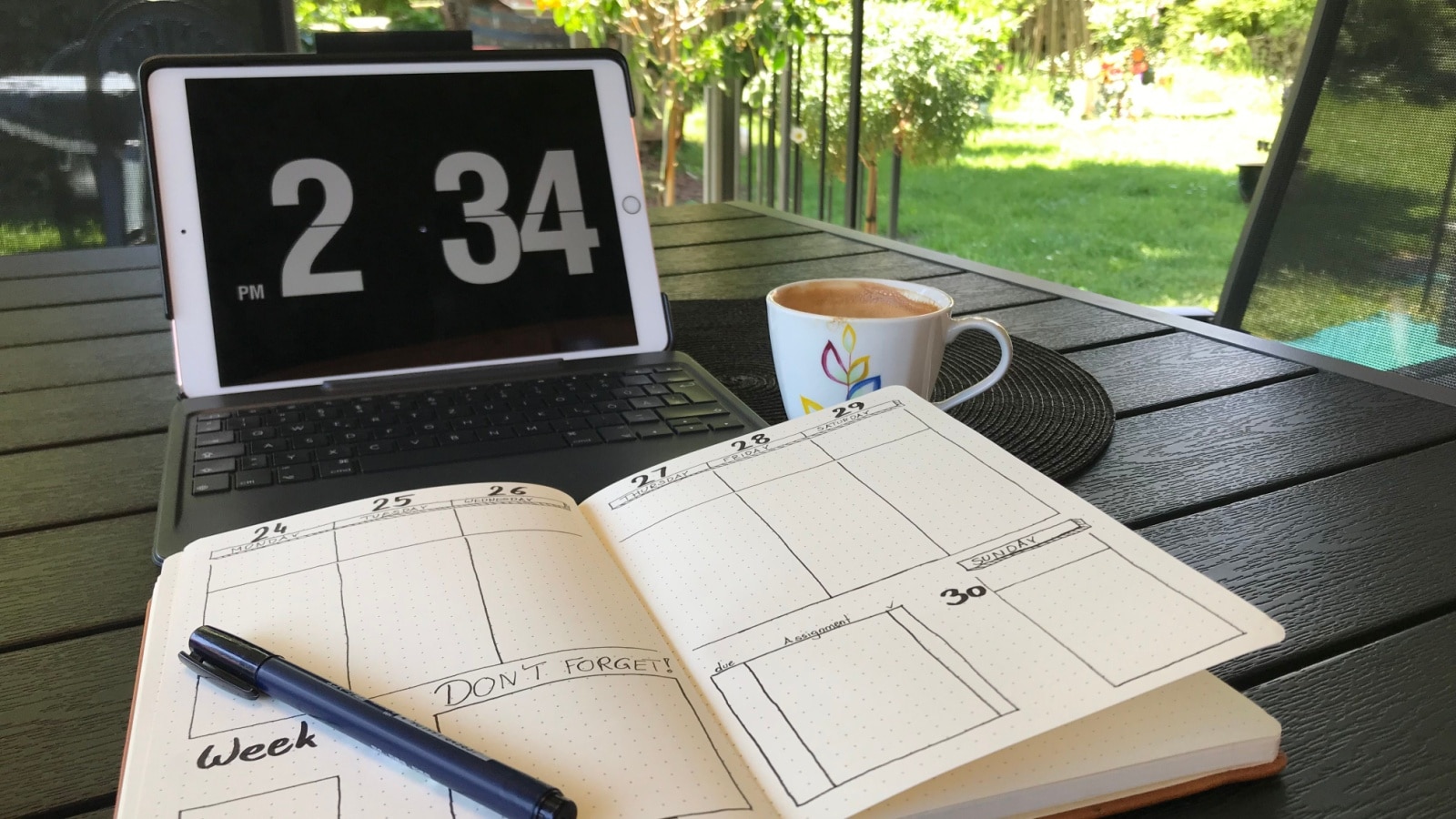 A bullet journal open on a desk with a simple weekly planner draw inside the pages to represent bullet journal weekly spread ideas.