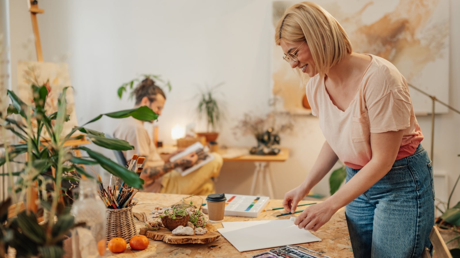 An artist with blank watercolor paper getting ready to prepare her canvas.