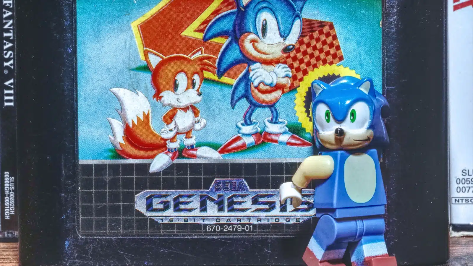 A toy Sonic the Hedgehog standing in front of a cartridge for Sonic the Hedgehog 2. 