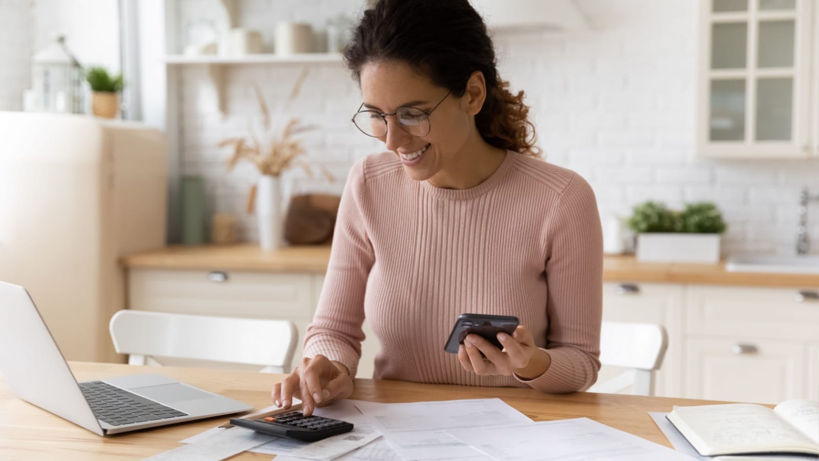 A young happy woman going over her financial picture with a big smile to represent calculating Coast FIRE.