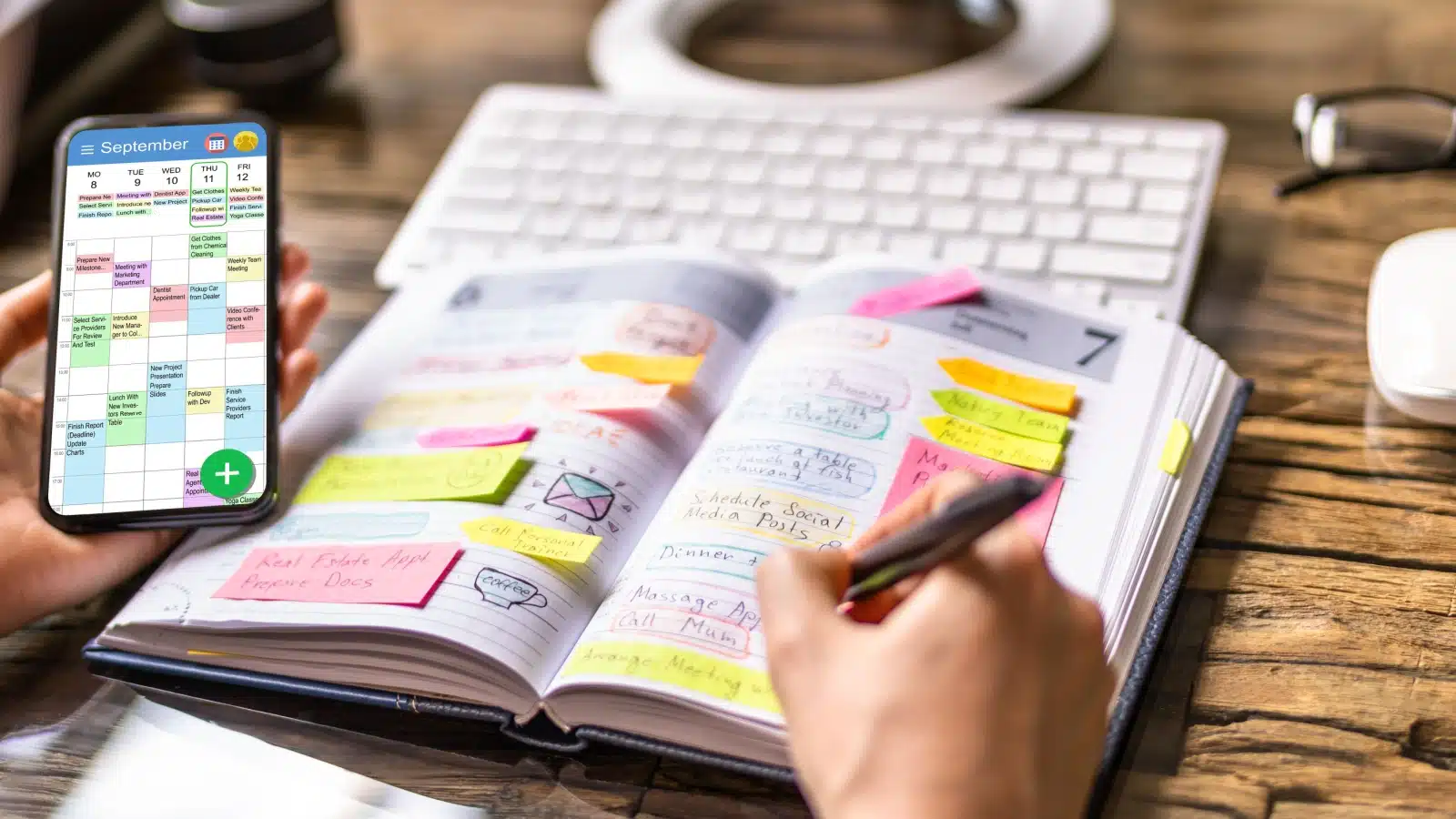 A woman checks her phone calendar and adds things to the to do list in her journal. 