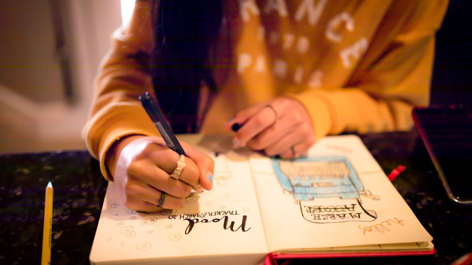 A woman starting a bullet journal with pretty spreads.