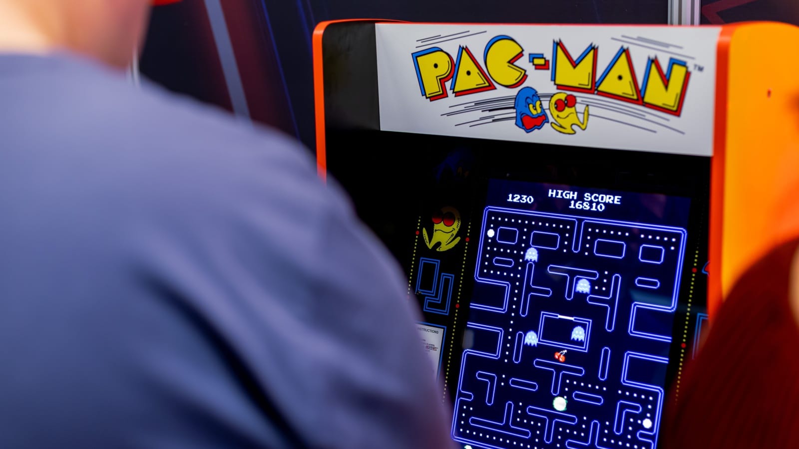 A man playing the vintage Pac-Man game.