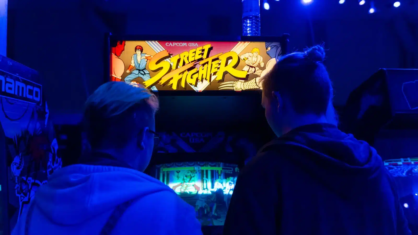 Two boys playing the Street Fighter arcade game. 