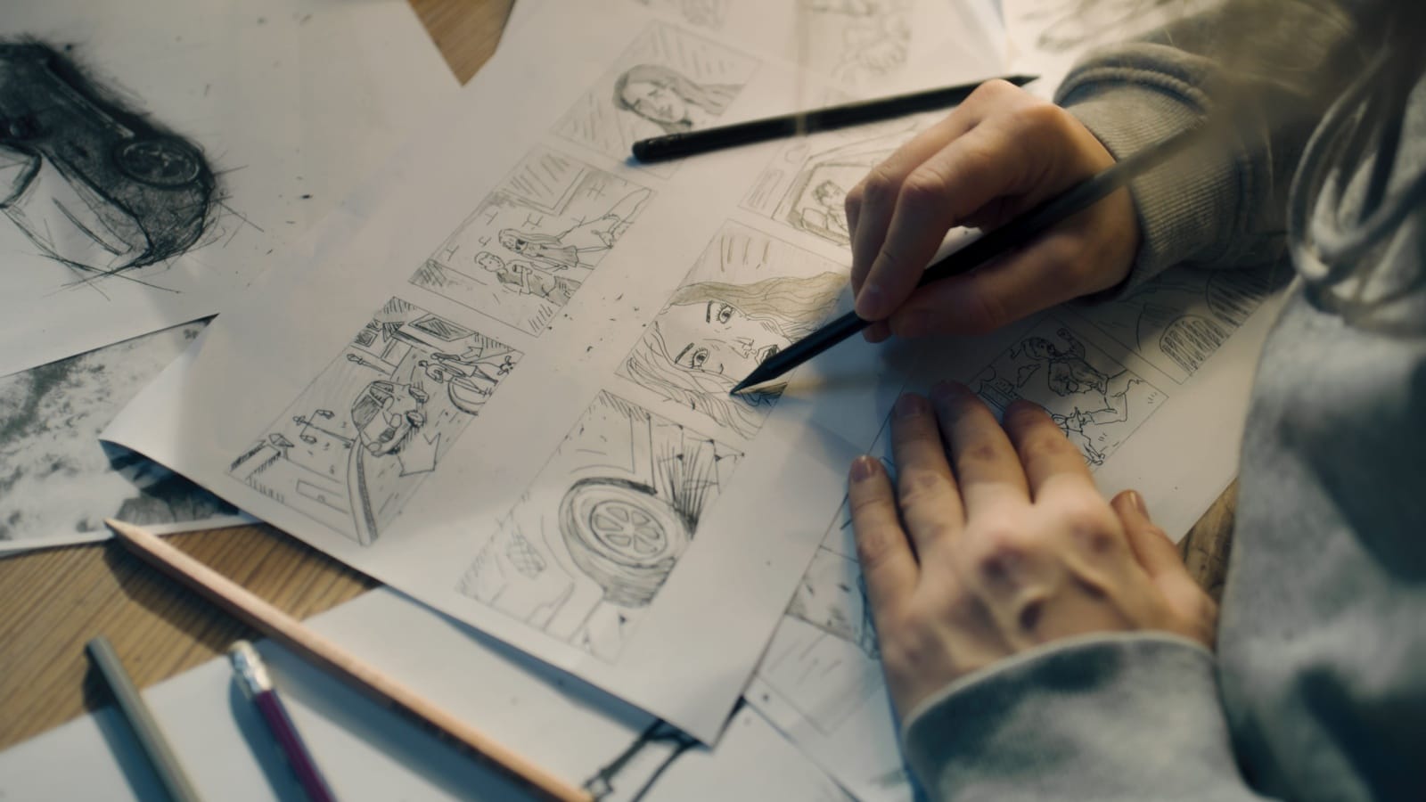 A woman sketches panels for a comic book to represent drawing ideas.