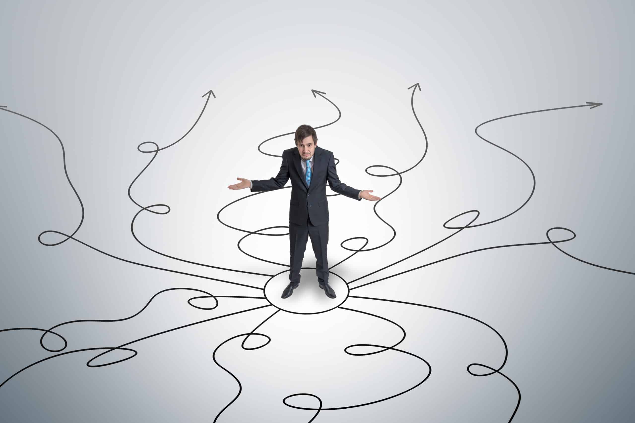 An unsure business man stands in a circle, surrounded by arrows to different options, to represent what should I do with my life.