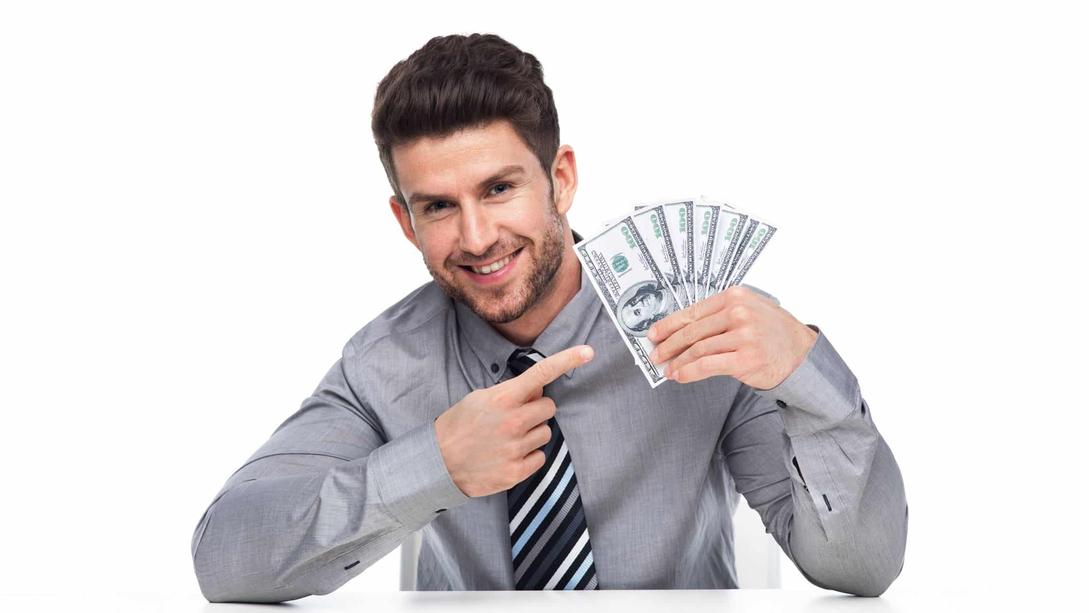 Man holding a pile of money and pointing to it