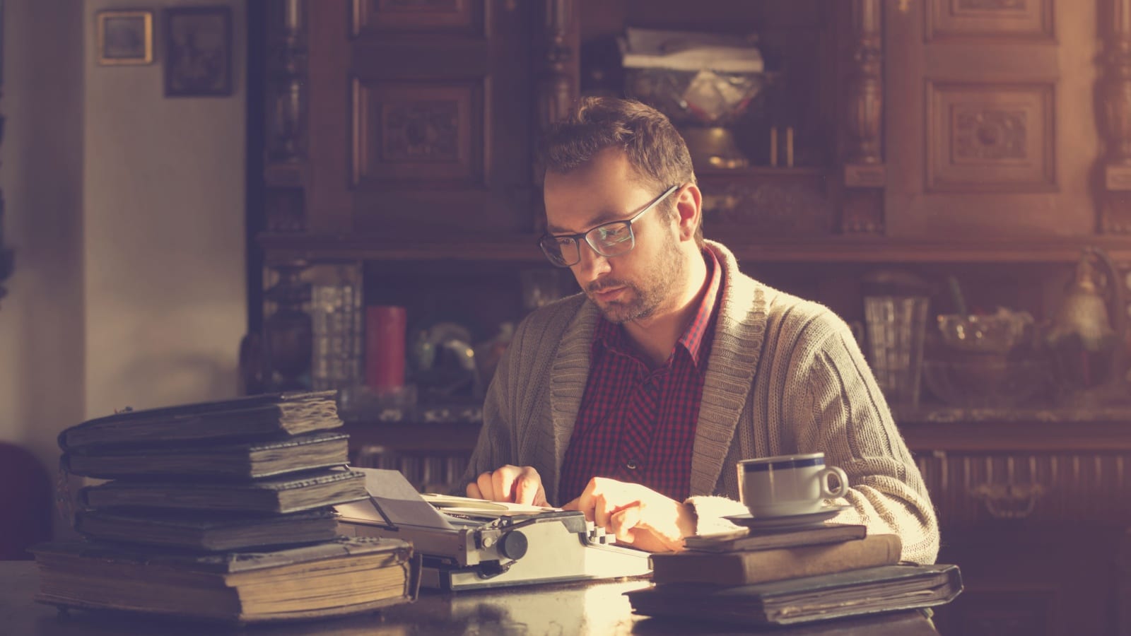 An author writing his novel on an old typewriter to represent literary elements.