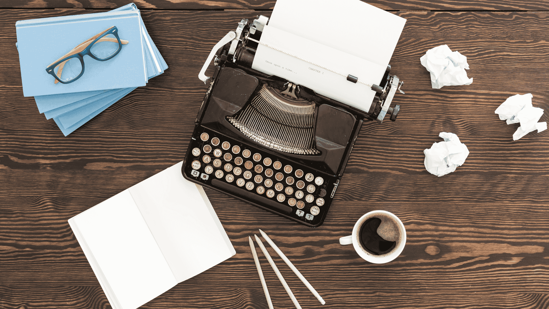 image of a typewriter and crumpled paper to represent a writer experimenting with literary techniques, narrative techniques, and literary devices