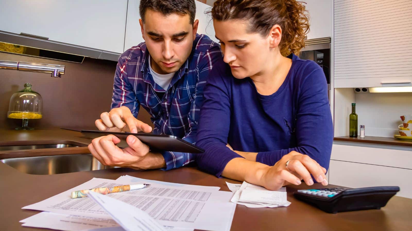 A couple studiously reviews their financial accounts together, to represent financial responsibility.