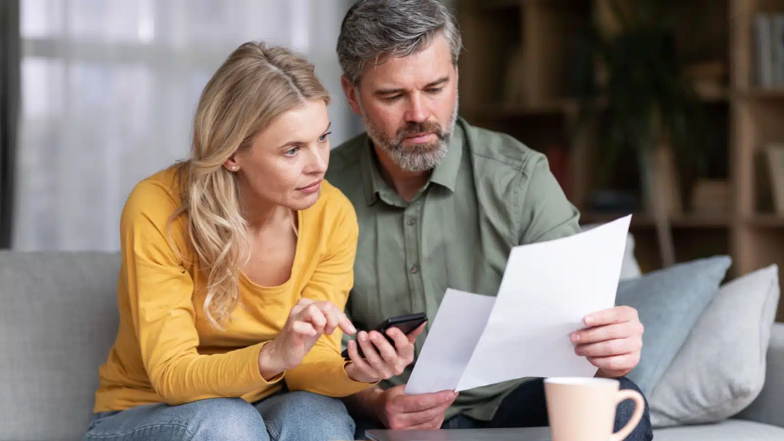 How much does life cost? Too much - ask this middle aged married couple solemnly looks at their bills.