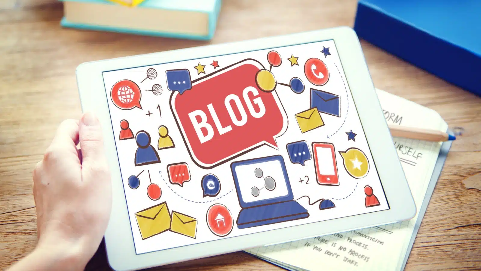 A colorful blog surrounded by icons representing blogging tools on a tablet. 