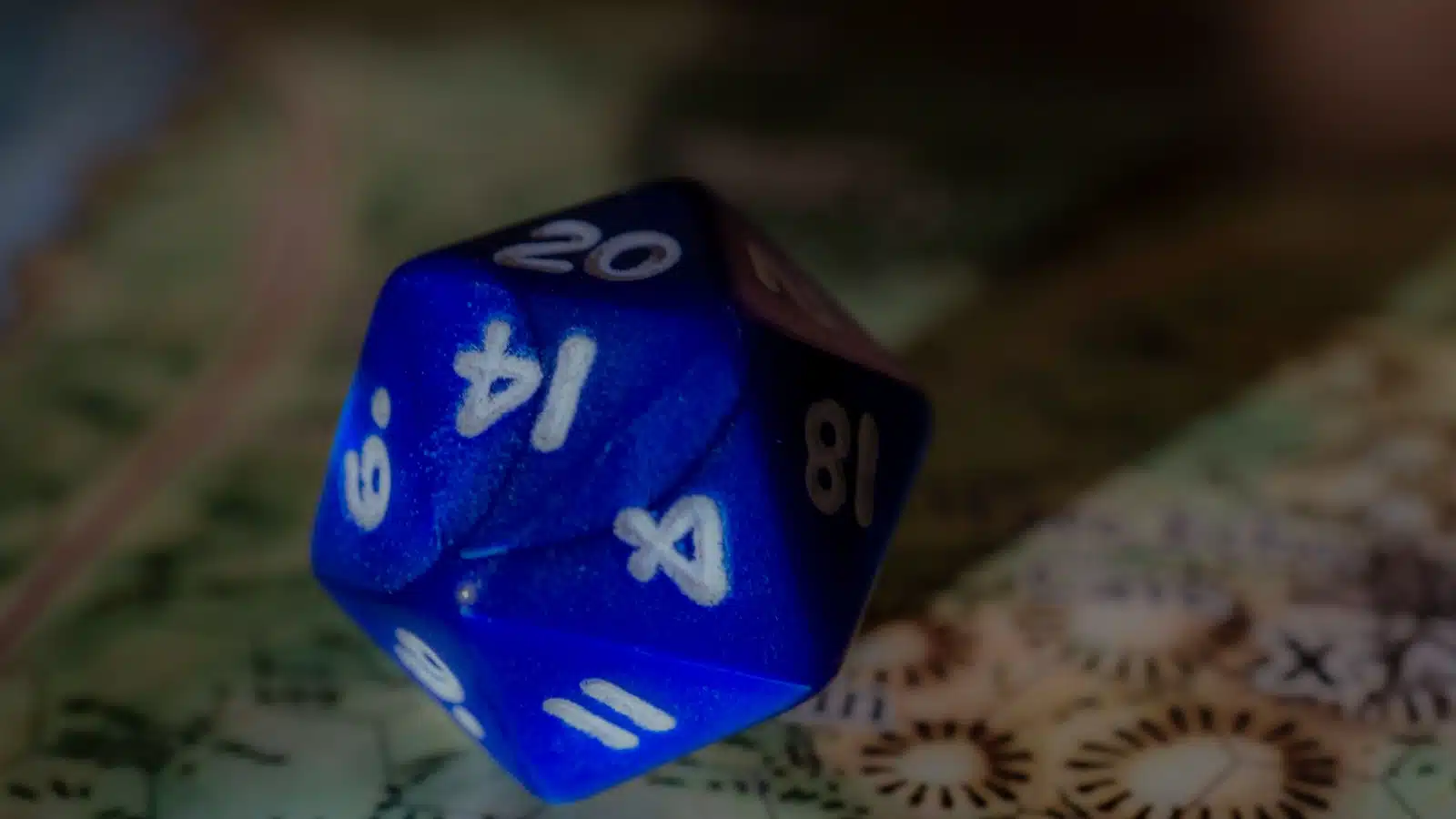 Close up of 20-sided D&D dice piece on a fantasy board.