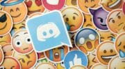 A graphic showing the Discord logo on top of a pile of standard emoticon to represent Discord emotes.
