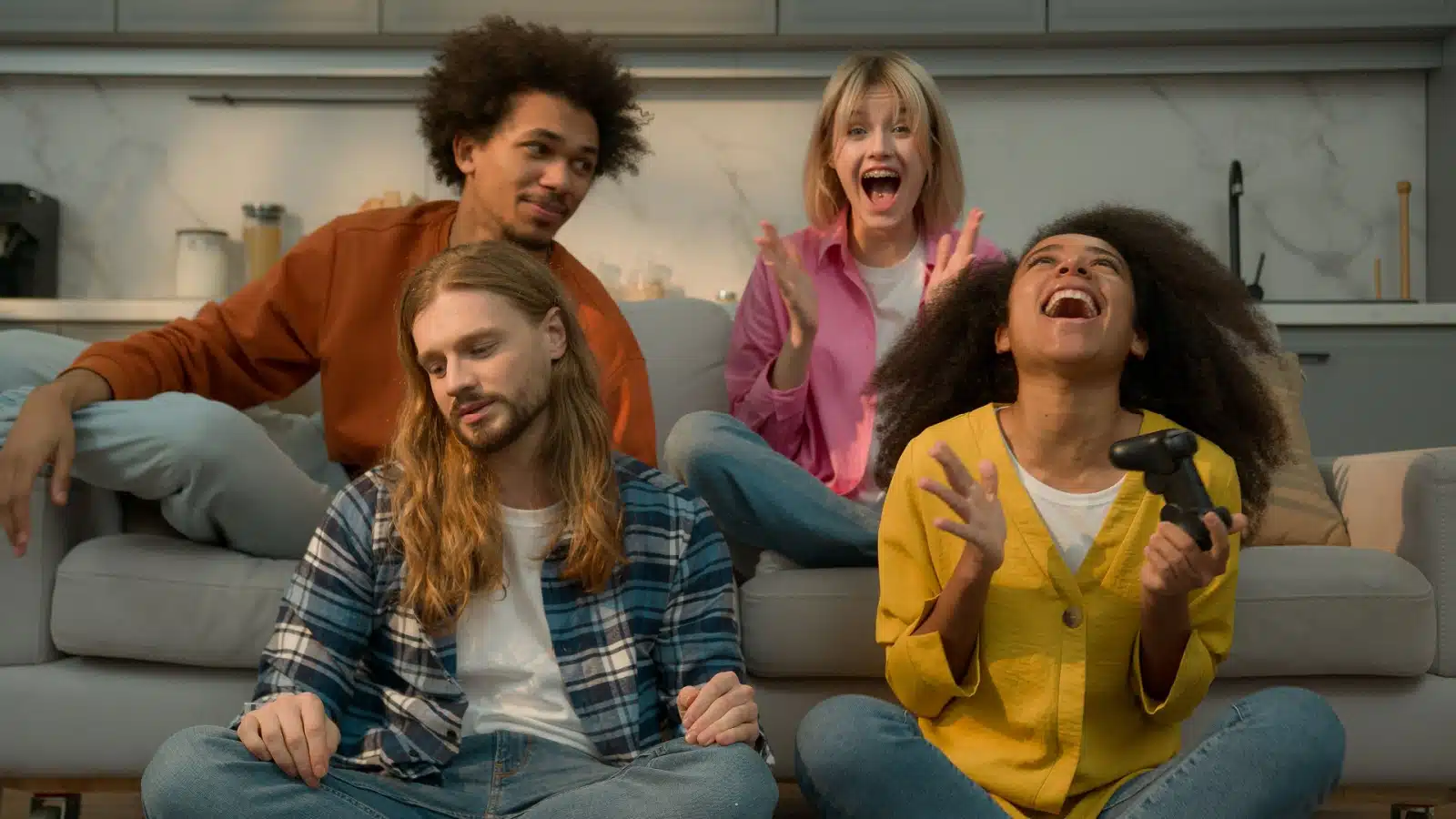 A group of friends laughing while playing video games together. It looks like they made a mistake in the game but they're laughing about it. 