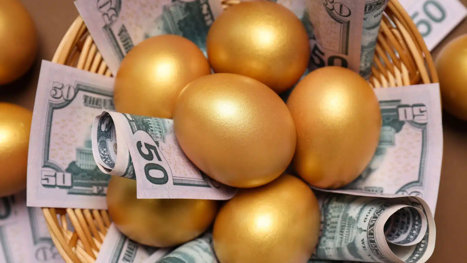 Golden eggs and dollar bills in a basket to represent nest egg prosperity.