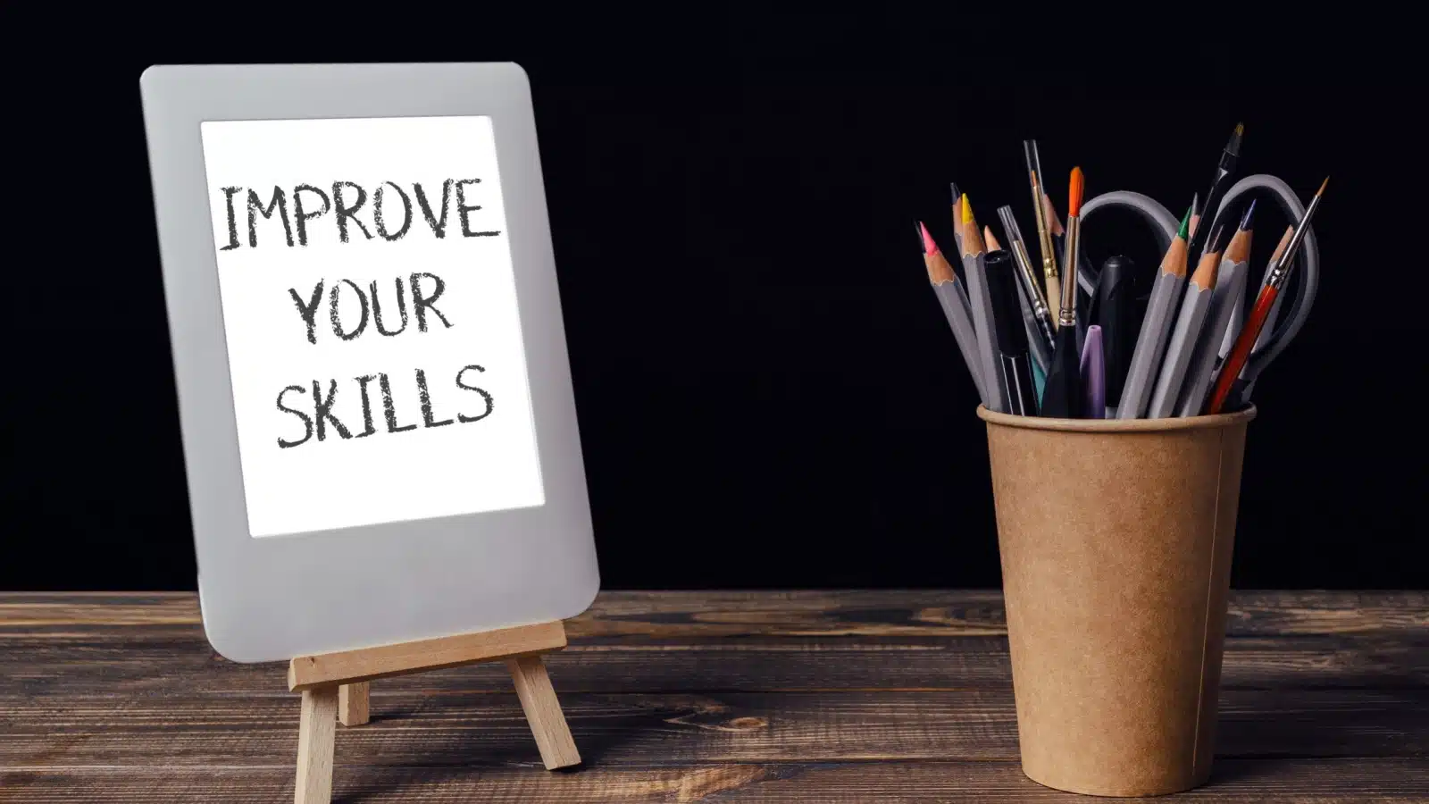 A white board saying "improve your skills" sits next to a cup of art supplies, reminding us that we must try at things in order to get better at them. 