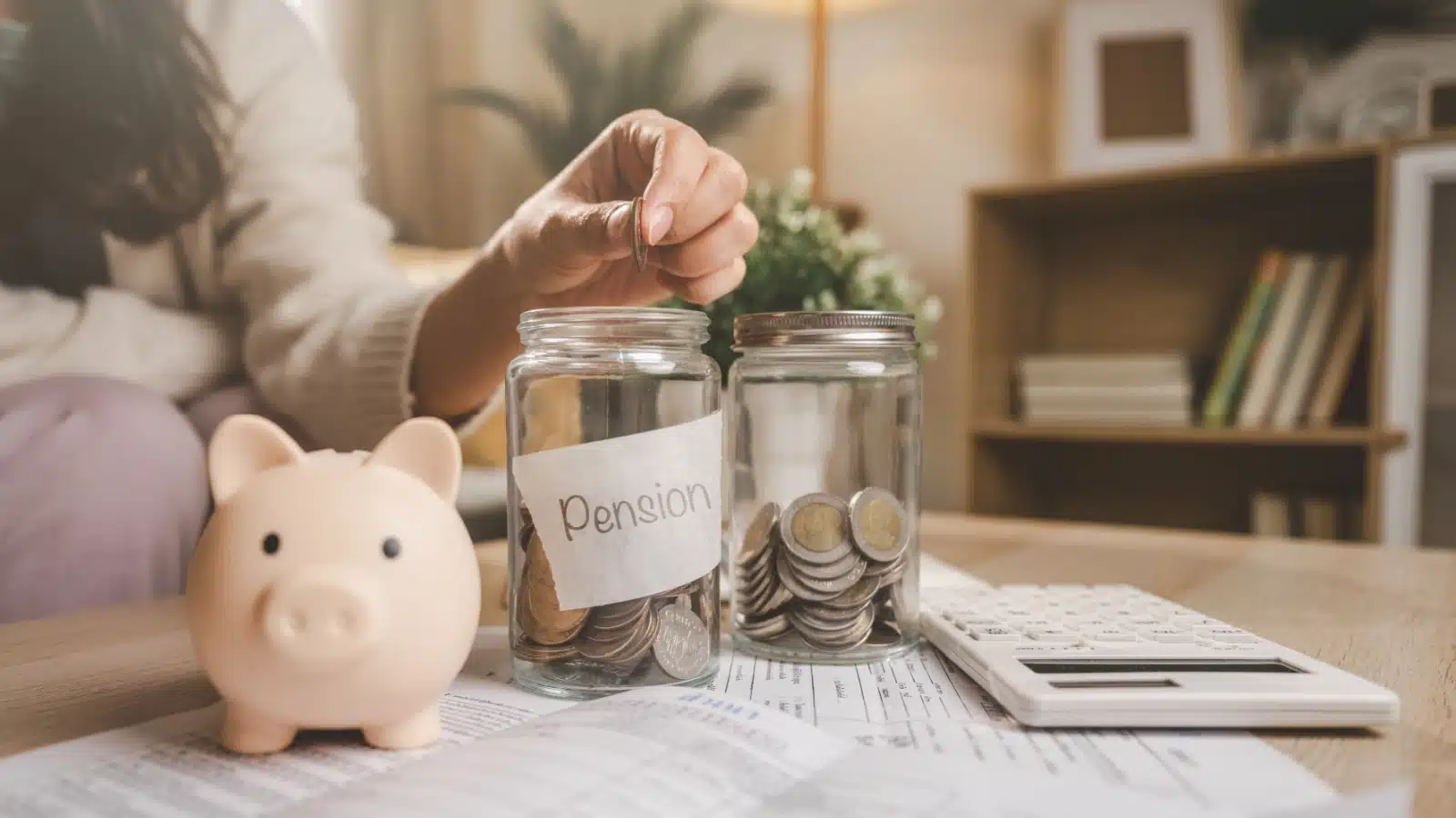 A woman dropping coins into different jars for money management.