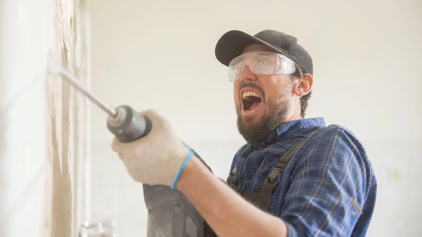 A man screams as he drills a hole into the wall, representing the horrors of real estate investing.