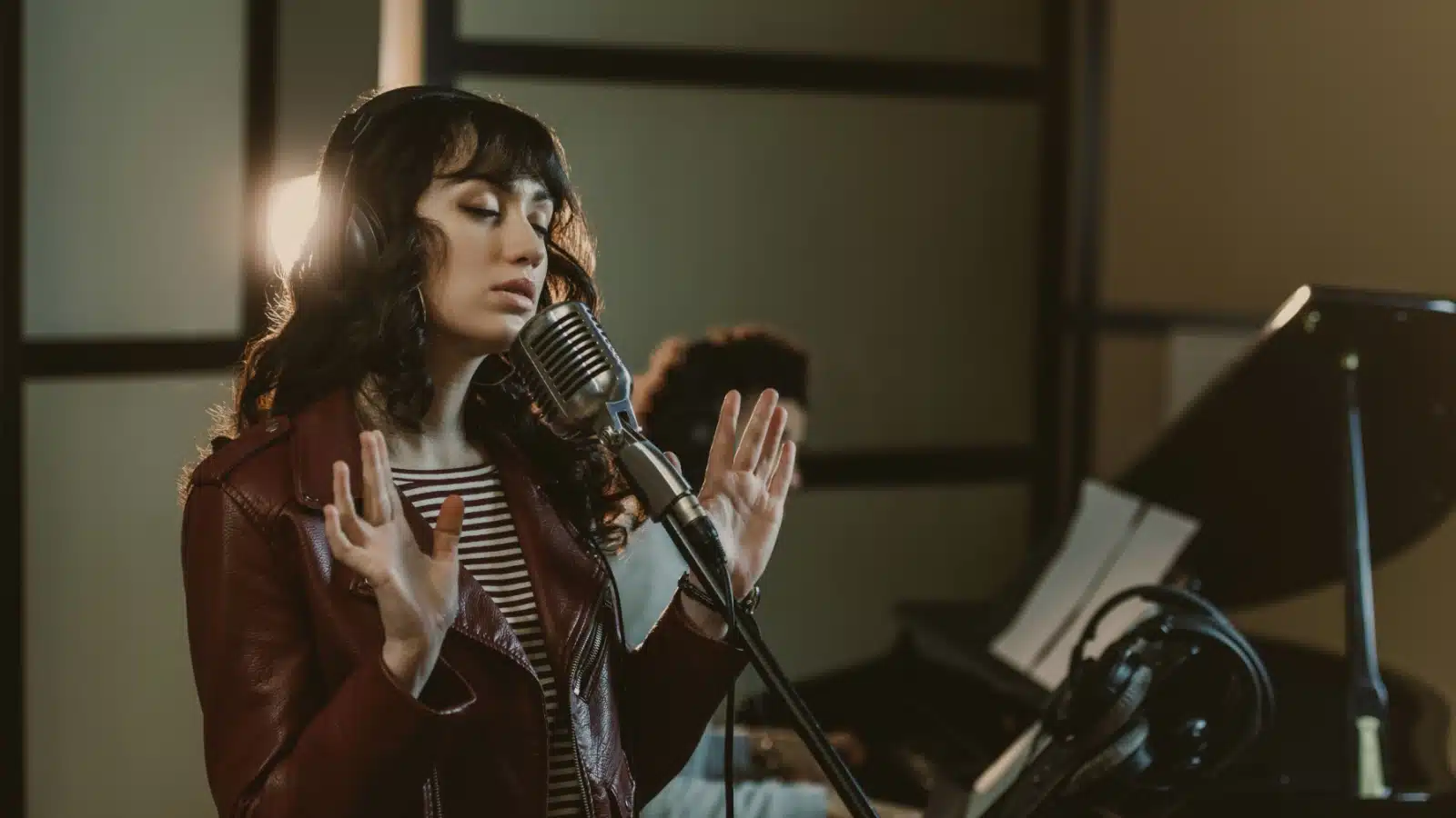 A woman recording a soulful song in a studio. 