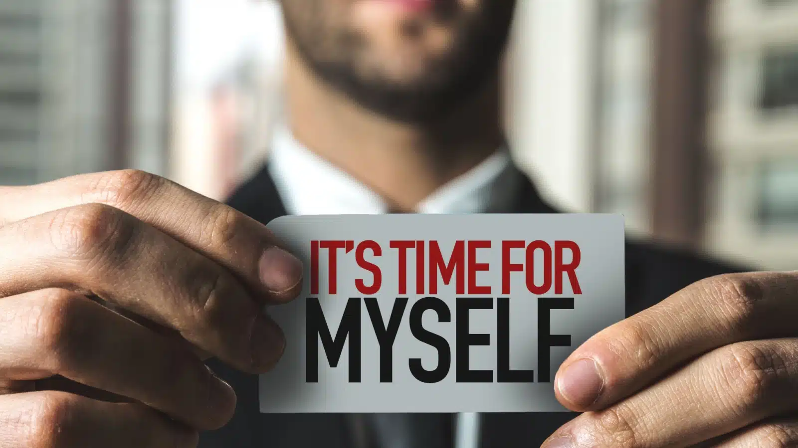 Businessman holding up a sign that says "It's time for myself"
