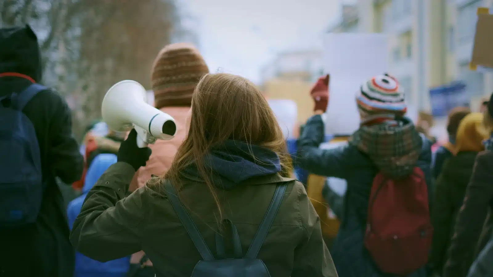 A female activist using a megaphone to elevate her voice, representing the power in her words.