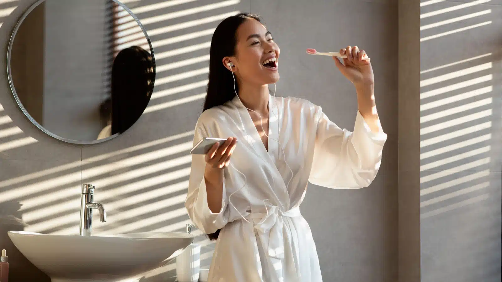 A happy woman brushes her teeth in the morning.