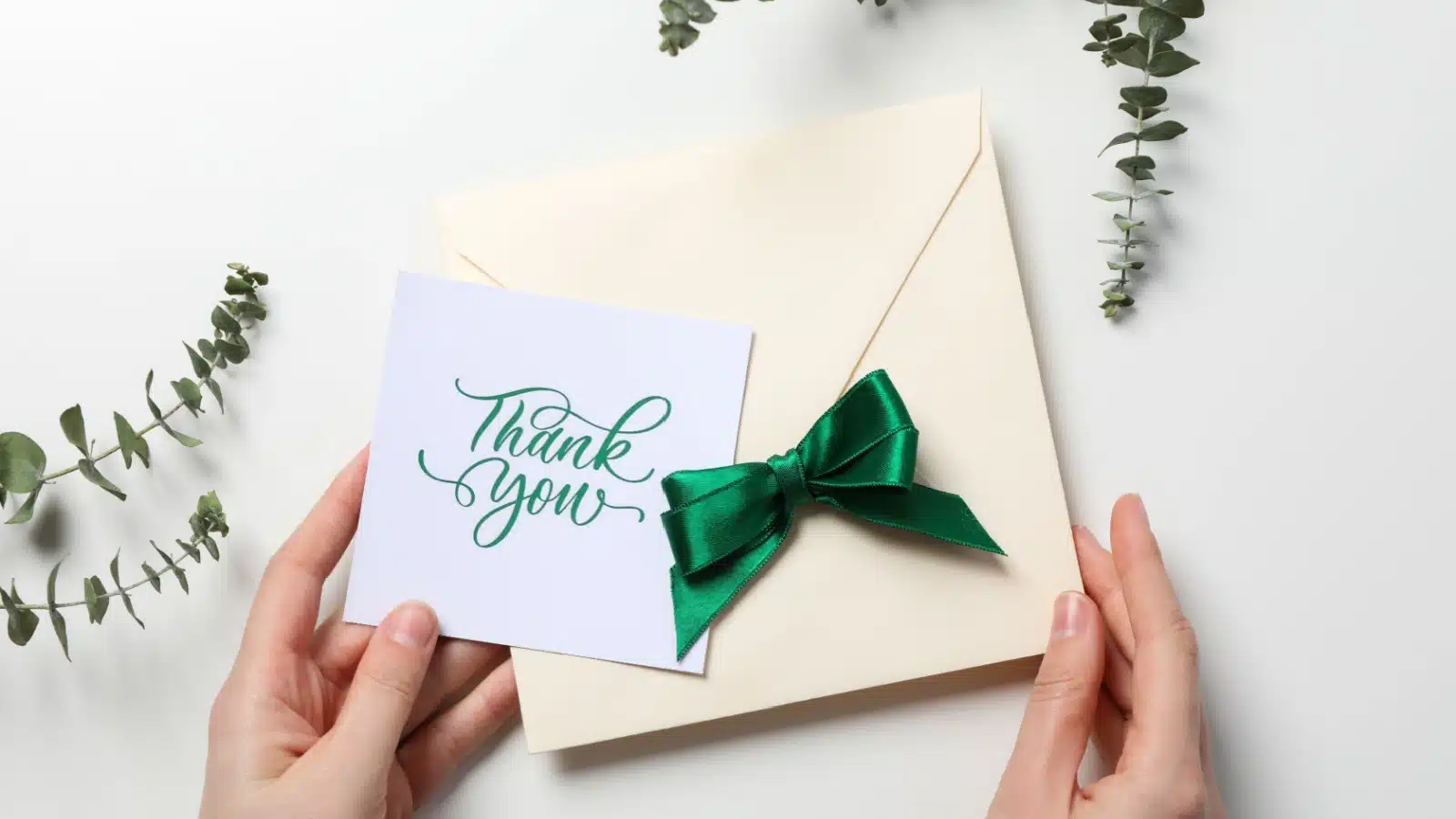 Woman filling an envelope with a thank you note.