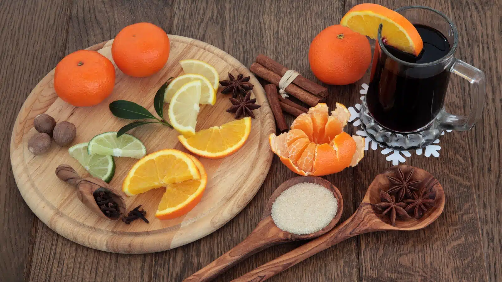 A cutting board featuring freshly cut citrus, clove, and cinnamon for making mulled wine.