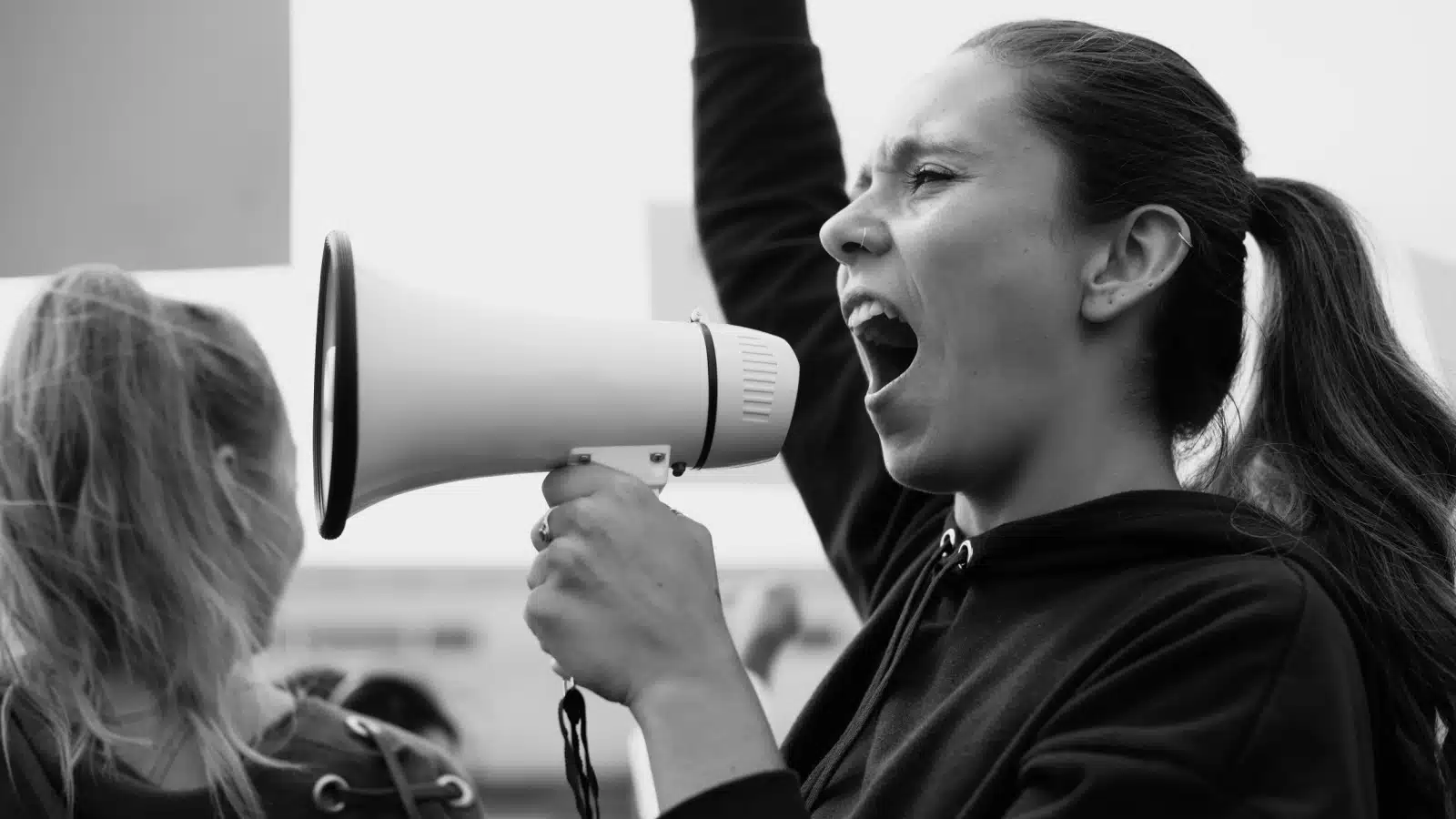 Black & White image of a woman with a megaphone protesting. 