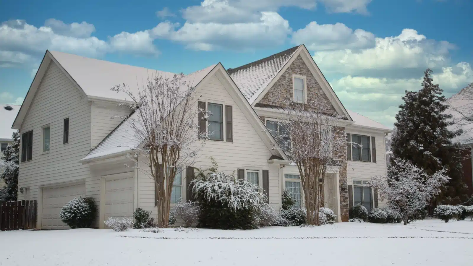 Exterior of a nice house with snow blanketing the ground around it.