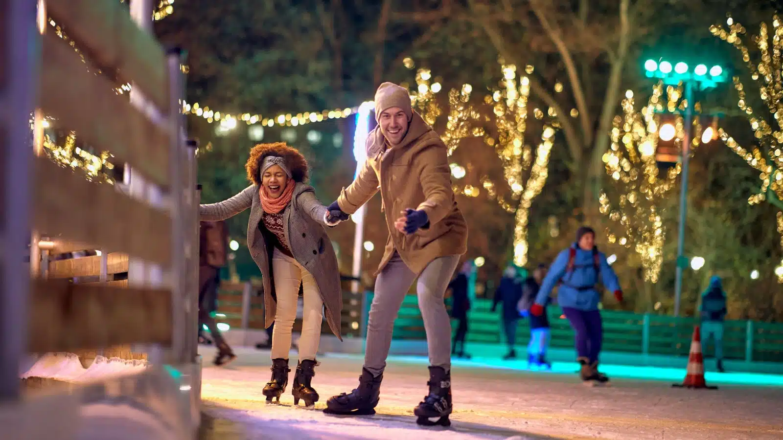 A happy couple spends the evening ice skating.