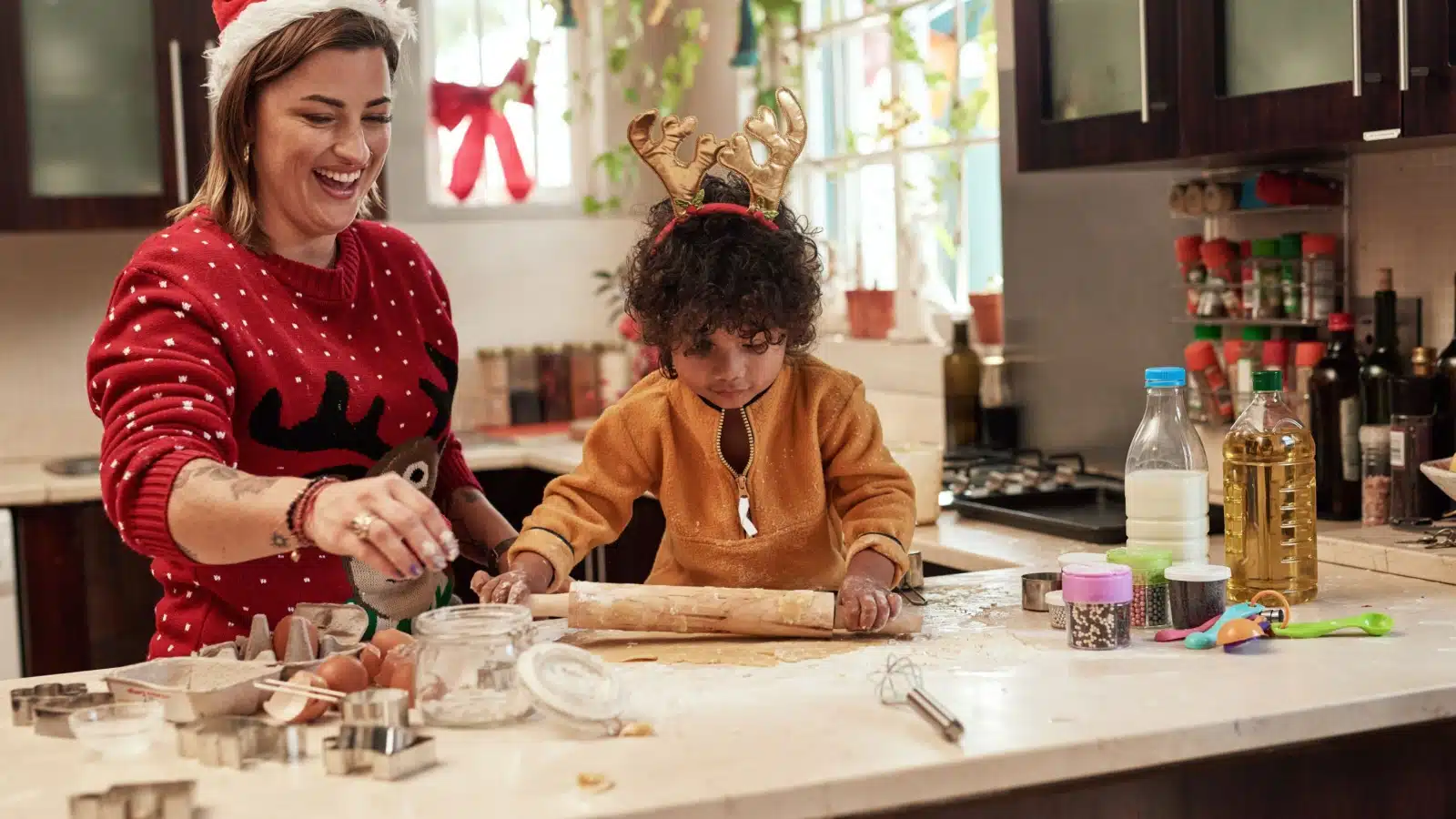 A mother and child roll dough for Christmas cookies.
