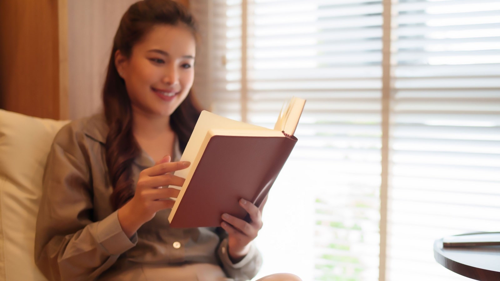 A woman smiles as she looks back on old journal entries.