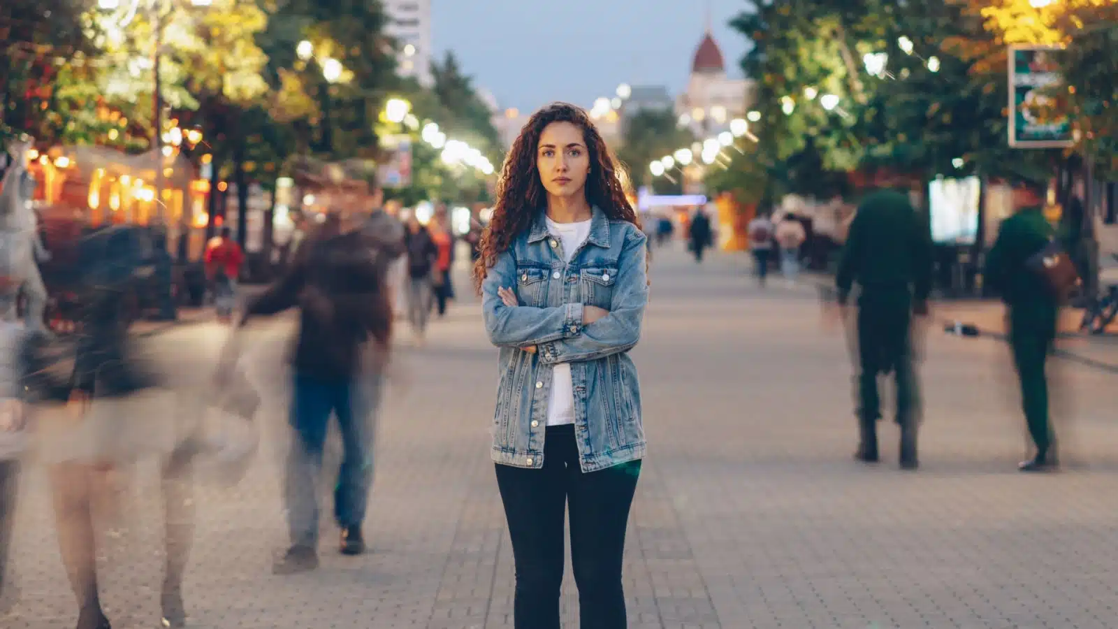 A woman stands still while everyone around her moves in a blur. The image represents how quickly time moves if we don't pay attention.