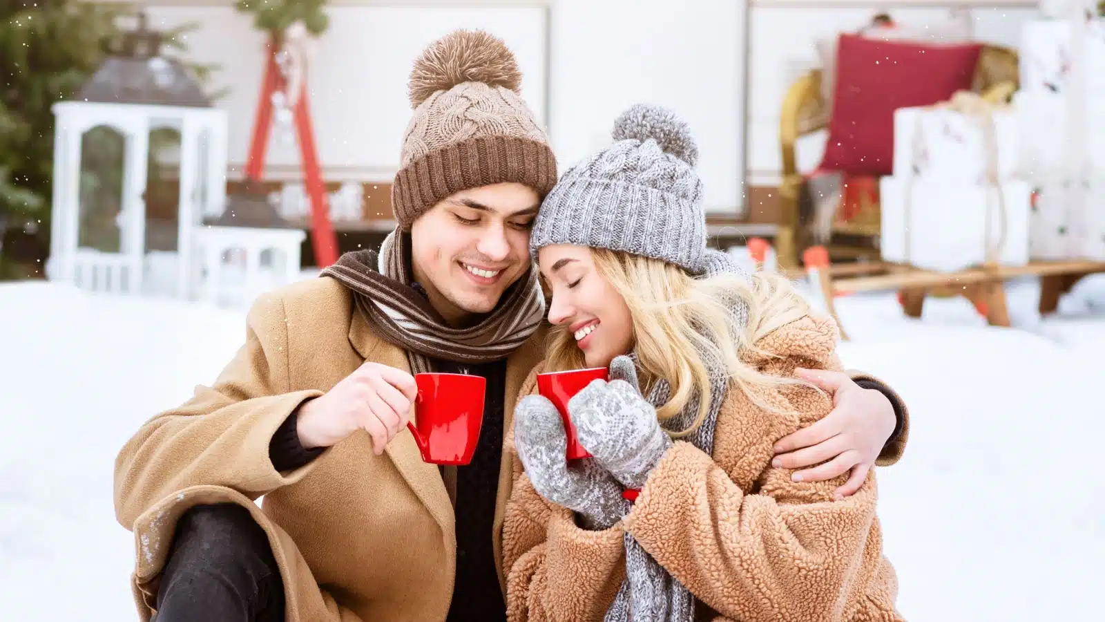 A couple snuggled up together, outside in winter, enjoying hot cocoa, to represent low cost winter activities for couples.