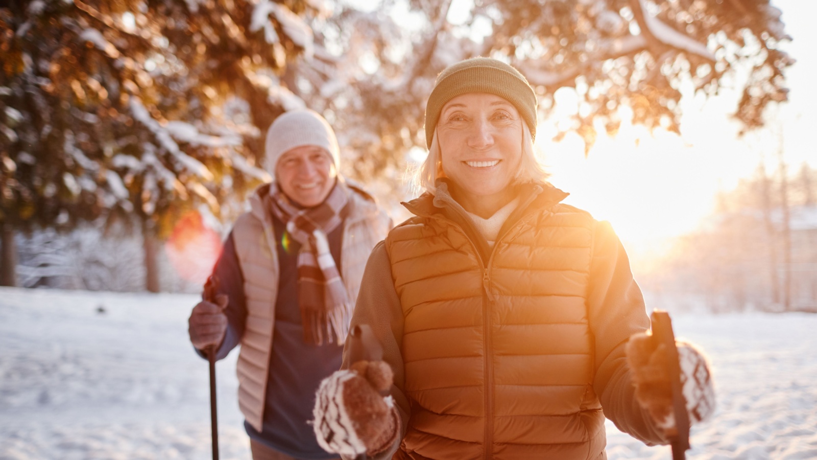 A senior couple takes a winter hike.