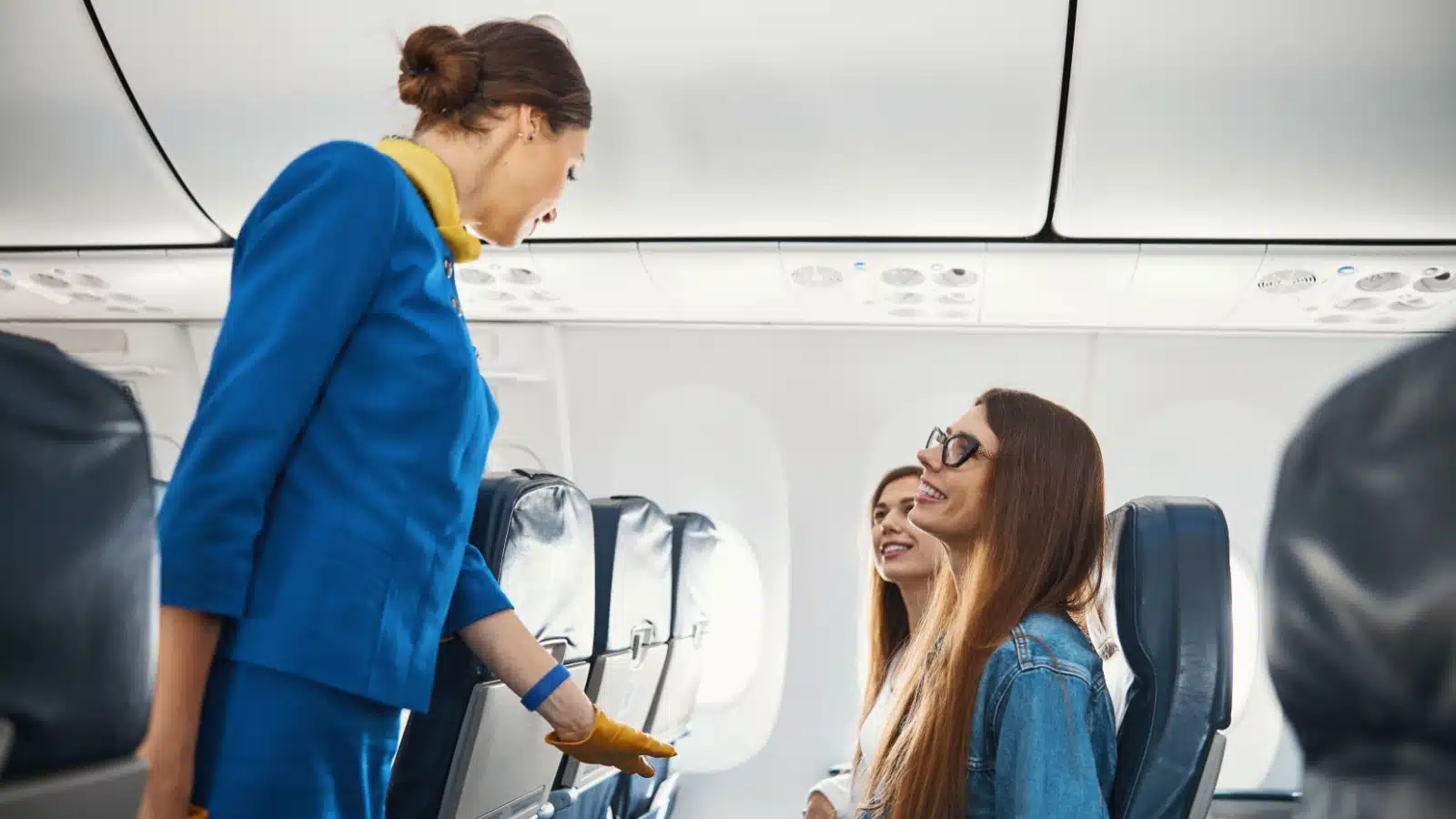 A flight attendant talking with passengers.