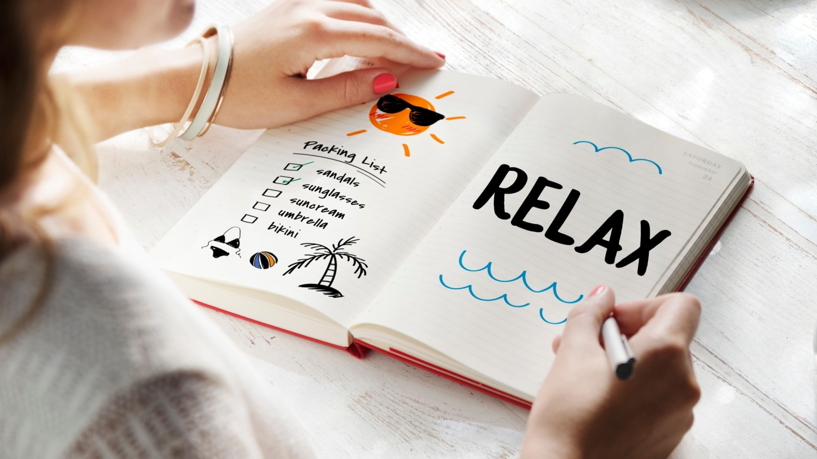 A woman using colorful bullet journal pens to create a unique spread.