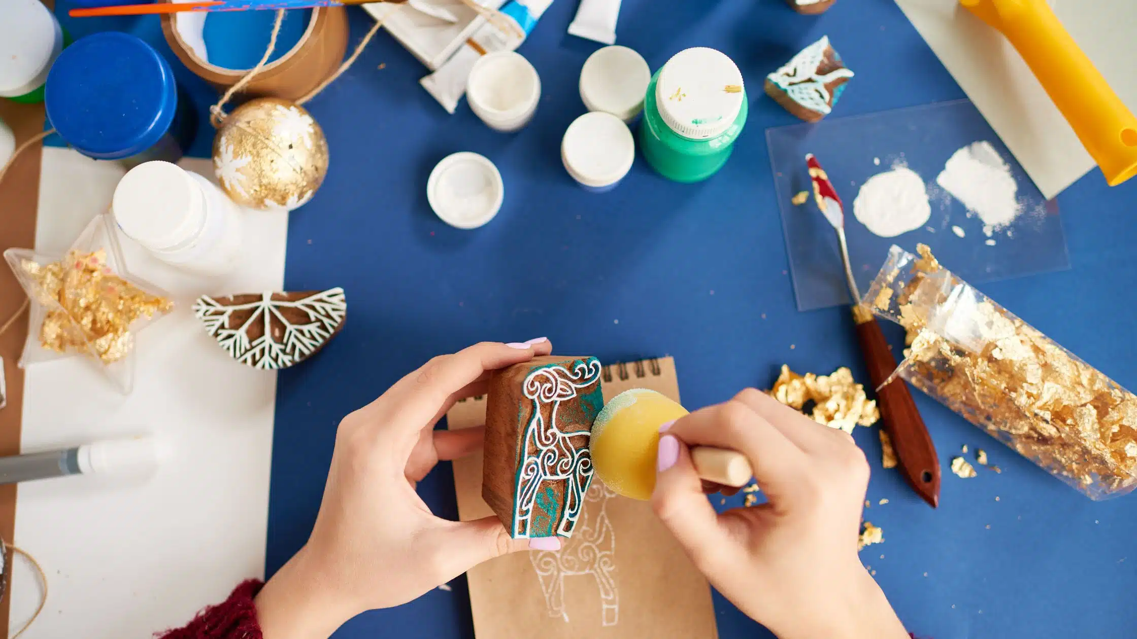 upclose of crafting table and hands painting a stamp