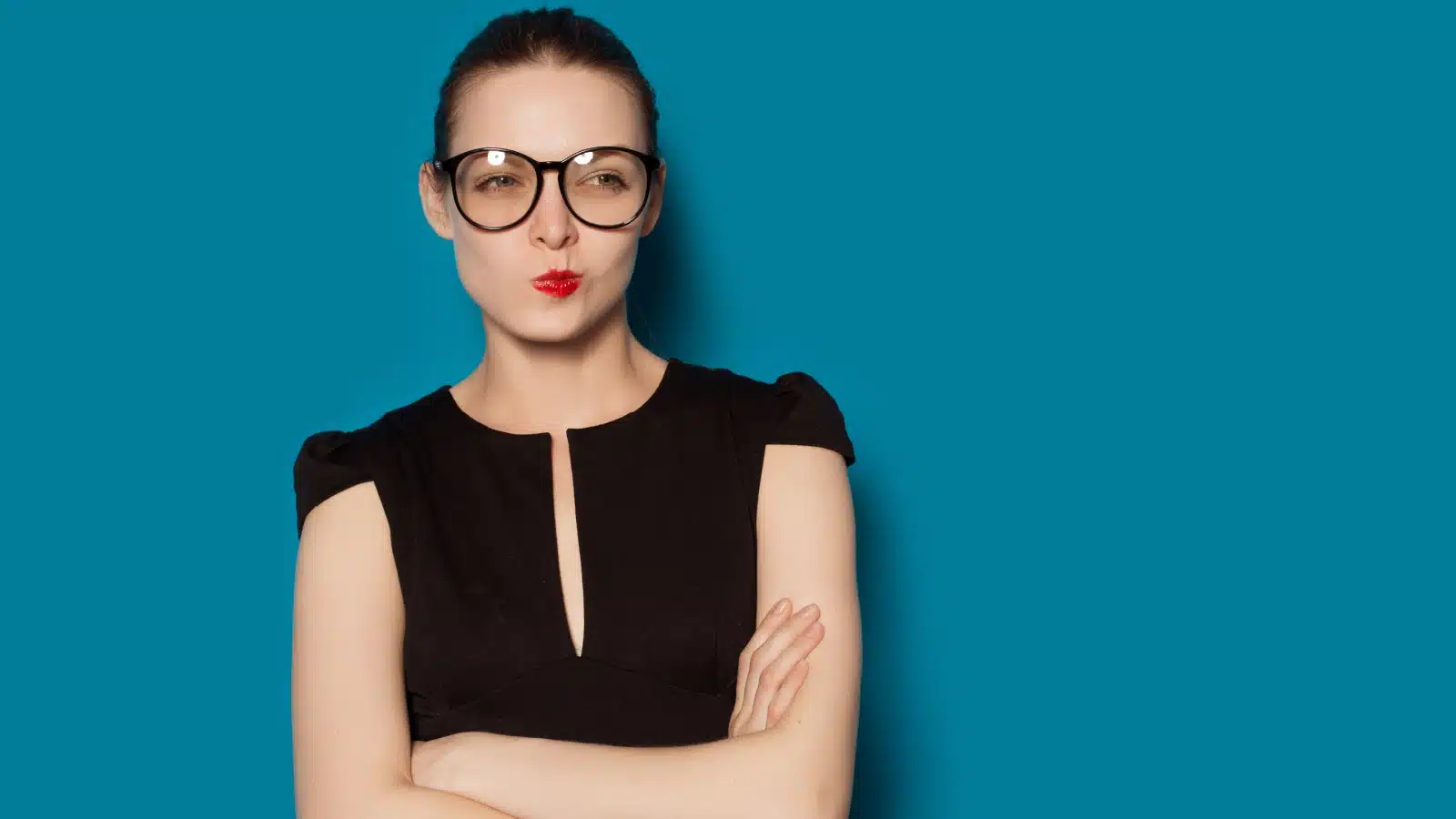 Portrait of a woman who looks like she's thinking critically about something on a blue background.