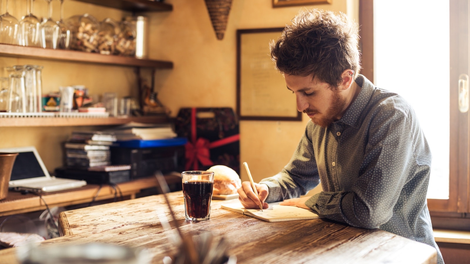 A young man sketching in his journal to represent low cost hobbies