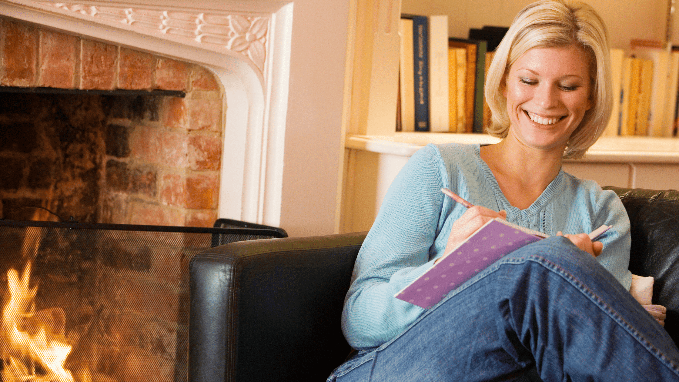 woman sitting by a fireplace writing in her journal to represent tups for starting a bullet journal