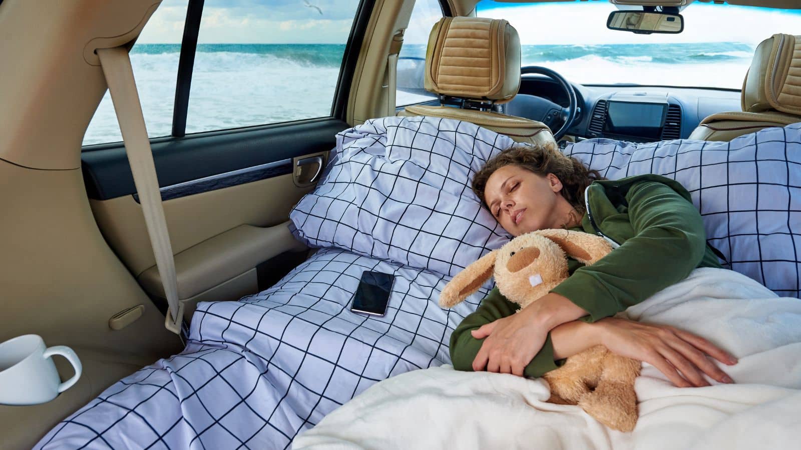 A woman sleeps in her car to represent sleeping in your car instead of a hotel on a road trip.
