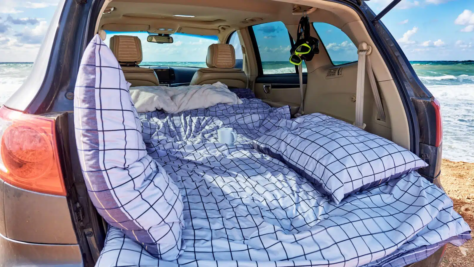 The back of an SUV transformed into a cozy bed, to represent sleeping in the car.