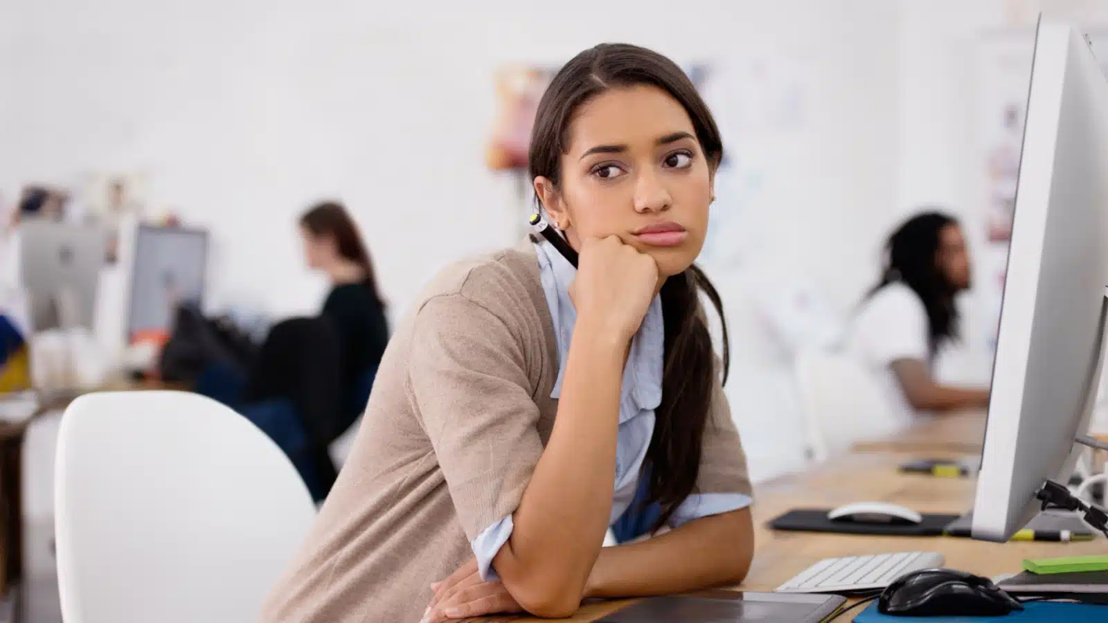 A bored student looks off in the distance. She's studying something smart, not something she loves, representing dream killers.