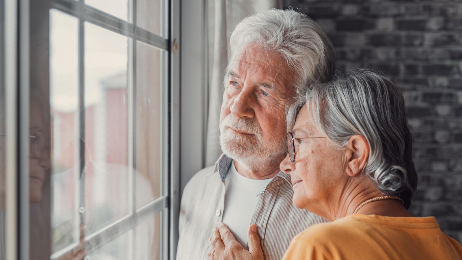 An older couple looks regretfully out the window. Do they regret having kids, or do they regret not having kids?