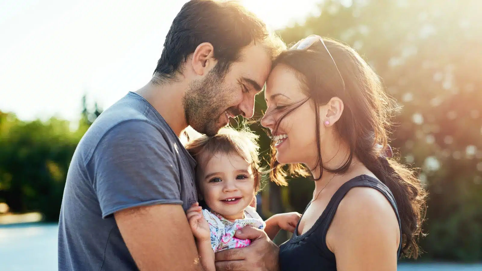 A happy couple holds their baby between them, to represent the crucial question "Will I change my mind about not having kids?"